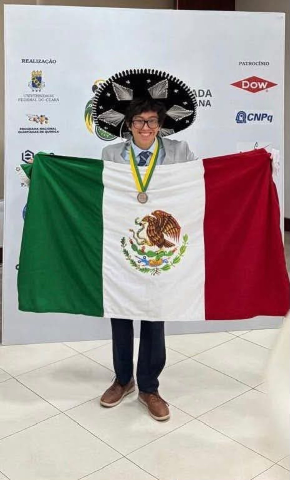 Luis Veudi Vivas Pérez con su medalla y la bandera mexicana